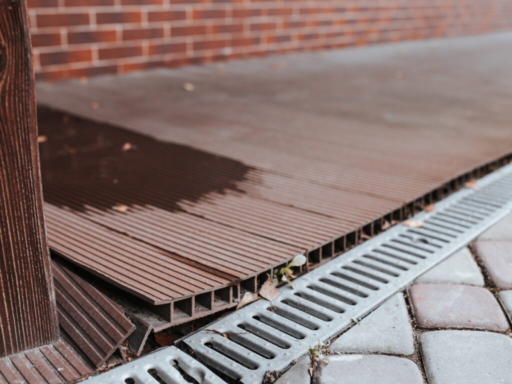 Improper drainage (like the faulty system shown by a home's exterior) can result in heavy basement flooding.